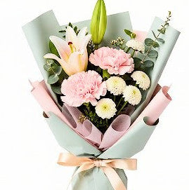 Bouquet of lillies wrapped in light green korean paper with a pink ribbon on a white background in a flower shop in Chilliwack