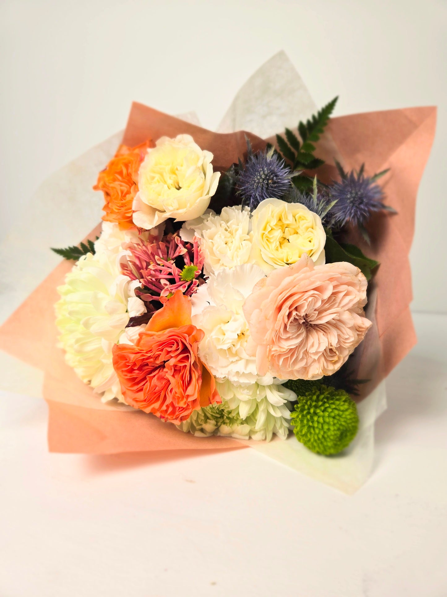 Blush and bloom pastel peach flower bouquet wrapped in paper and tied with a bow. Flowers in Chilliwack BC