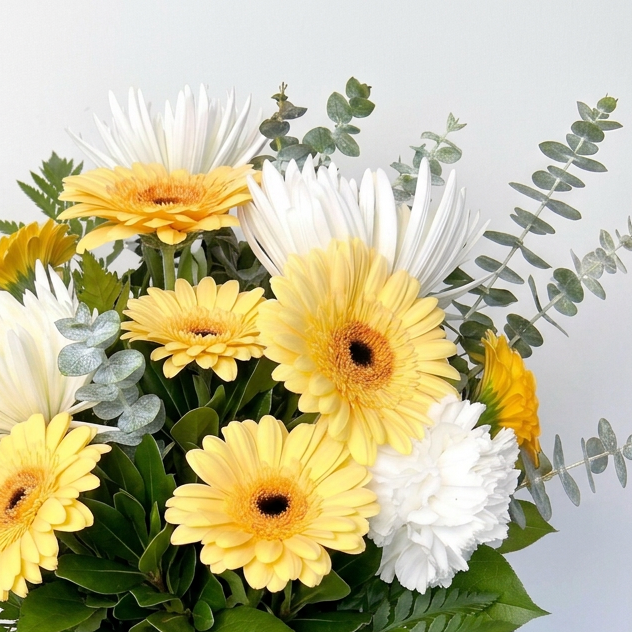 Bouquet of orange and white flowers in a clear vase with an orange ribbon on a light background. Delivery in Chilliwack Cultus Lake and Sardis.
